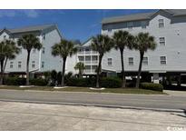 Condos featuring neatly landscaped grounds and mature palm trees on a clear sunny day at 6103 N Ocean Blvd. # C-6, North Myrtle Beach, SC 29582