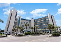 A daytime, street-level view of the oceanfront building featuring palm trees and striking architecture at 7100 N Ocean Blvd. # 320, Myrtle Beach, SC 29572