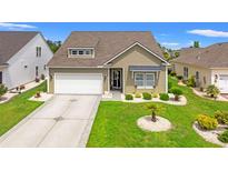 Charming single-Gathering home boasts a well-manicured lawn, attached garage, and inviting entrance at 802 Devon Estate Ave., Myrtle Beach, SC 29588