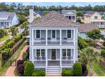 Charming two-story home featuring double porches, columns, and manicured landscaping at 8185 Sandlapper Way, Myrtle Beach, SC 29572