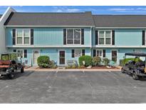 Charming condo with a well-kept exterior and golf carts in the parking area at 843 Villa Dr. # 843, North Myrtle Beach, SC 29582