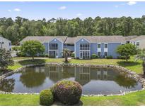 Beautiful exterior view of the condo complex featuring a serene pond and lush landscaping at 8862 Duckview Dr. # E, Surfside Beach, SC 29575