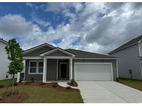 Charming single-Gathering home featuring a two-car garage and manicured front yard at 1014 Laconic Dr., Myrtle Beach, SC 29588