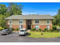 Apartment building featuring brick and beige siding, complemented by lush landscaping at 1015 Elm St. # 4, Conway, SC 29526