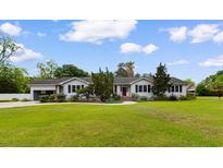 Charming single story home with lush landscaping and a well-maintained lawn on a sunny day at 115 Ford Ave, Mullins, SC 29574