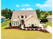 Charming single-story home with a manicured lawn, a red front door, and a well-maintained landscape at 1367 Bermuda Grass Dr., Myrtle Beach, SC 29579
