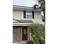 Inviting townhouse with a red front door, brick facade, and lush palm trees at 1432 Highway 544 # B2, Conway, SC 29526