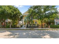 Charming yellow two-story home with black iron fencing and lush, mature landscaping at 1516 James Island Ave., North Myrtle Beach, SC 29582