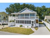 Charming two-story home featuring double balconies, a screened-in porch, and a well-manicured lawn at 1622 Havens Dr., North Myrtle Beach, SC 29582