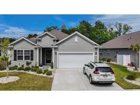 Charming one-story home featuring a two-car garage, well-manicured lawn, and attractive gray siding at 251 Juniata Loop, Little River, SC 29566