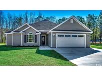 Charming single-story home featuring a two-car garage, well-manicured lawn, and classic architectural details at 2690 Hugo Rd., Conway, SC 29527