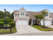 Charming two-story home features a well-manicured lawn and an attached two-car garage with an American flag displayed at 3334 Volterra Way # 3334, Myrtle Beach, SC 29579