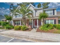 Charming brick townhome featuring a welcoming red door and well-maintained landscaping at 3565 Crepe Myrtle Ct. # 3565, Myrtle Beach, SC 29577