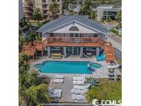 Stunning backyard featuring a pool, spa, sundeck, lounge chairs, and outdoor seating area at 4501 S Ocean Blvd., North Myrtle Beach, SC 29582
