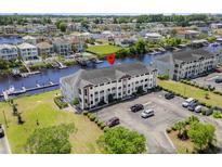 Aerial view of a three-story condo building near waterway, parking and manicured lawn at 4524 N Plantation Harbour Dr. # B3, Little River, SC 29566