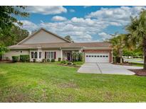 Charming single-story home featuring a well-manicured lawn, brick accents, and an attached two-car garage at 475 Misty Hammock Dr. # 475, Murrells Inlet, SC 29576