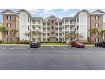 Three-story condo building with beach architecture, parking, and light yellow siding at 4812 Magnolia Lake Dr. # 102, Myrtle Beach, SC 29577