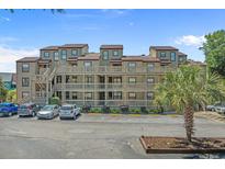 Three-story condo building with wooden balconies, parking, and a well-maintained landscape at 501 Maison Dr. # G-7, Myrtle Beach, SC 29572