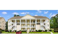 Inviting three-story condo building with multiple balconies, white railings, and exterior staircases at 5840 Longwood Dr. # 303, Murrells Inlet, SC 29576
