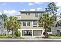 Two-story beach home featuring a ground-level garage and palm tree landscaping at 616 S Palmetto Way, Surfside Beach, SC 29575