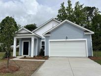 Charming single-story home with light blue siding, a white garage door, and a well-manicured front yard at 642 Muster Field Ct., Conway, SC 29526