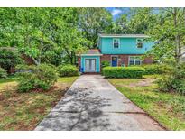 Charming two-story home with blue siding, brick accents, and a well-maintained front yard at 715 9Th Ave. S, Surfside Beach, SC 29575