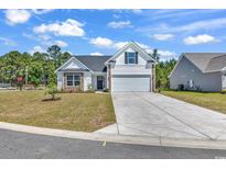 Charming one-story home with white siding, stone accents, and a spacious two-car garage with long driveway at 914 Padgett Lane, Conway, SC 29526