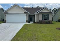 Charming single Gathering home with a two car garage, stone accents, and manicured lawn at 918 Padgett Lane, Conway, SC 29526