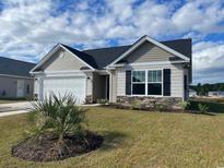 Charming single-story home with a two-car garage, manicured lawn, and decorative stone accents at 930 Padgett Lane, Conway, SC 29526