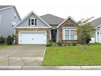 Charming home featuring stone accents, a two-car garage, and a beautifully manicured front yard at 932 Mildred Ct., Murrells Inlet, SC 29576