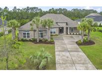 Beautiful one-story home with a well-manicured lawn, palm trees, and a spacious driveway at 2204 Woodstork Dr., Conway, SC 29526
