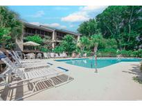 Inviting community pool area with ample lounge chairs and lush landscaping at this condo community at 223 Maisons Dr. # C8, Myrtle Beach, SC 29572