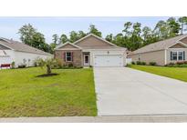 Charming single-story home featuring a well-manicured lawn, concrete driveway, and an attached two-car garage at 252 Legends Village Loop, Myrtle Beach, SC 29579