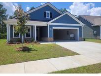 Charming blue single-Gathering home with an attached garage and freshly planted front lawn at 283 River Edge Dr., Myrtle Beach, SC 29588