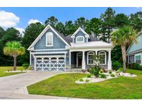 Charming blue two-story home featuring a well-manicured lawn and inviting curb appeal at 2909 Moss Bridge Ln., Myrtle Beach, SC 29579