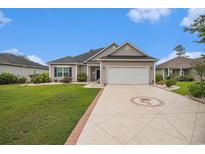 Charming single-story home featuring a well-manicured lawn and patterned driveway leading to a two-car garage at 325 Galway Ct., Longs, SC 29568