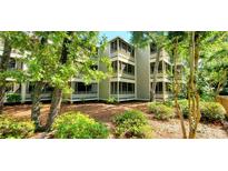 Beautiful three-story condo building with screened-in porches, surrounded by trees and lush landscaping at 415 Ocean Creek Dr. # 2161, Myrtle Beach, SC 29572