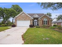 Charming single-story brick home with manicured lawn, two car garage and mature trees at 44 Hamby Dr., Pawleys Island, SC 29585