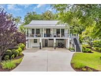 Charming two-story home with a metal roof, double balconies, and a spacious driveway at 476 Lakeshore Dr., Pawleys Island, SC 29585