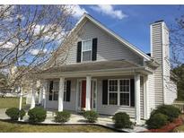 Charming home featuring light gray siding, a red front door, a covered porch, and manicured landscaping at 4949 Southgate Pkwy., Myrtle Beach, SC 29579