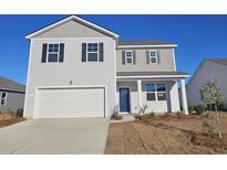 Charming two-story home with gray siding, black shutters, and a two-car garage on a sunny day at 738 Chazen Way, Longs, SC 29568