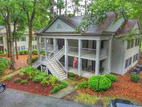 Charming two-story condo with double balconies, beautiful landscaping, and an American flag at 75-4 Weehawka Way # 4, Pawleys Island, SC 29585