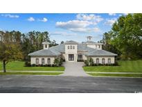 Beautiful one-story home with manicured lawn, symmetrical curb appeal and elegant white stucco exterior at 9485 Ronda Ct., Myrtle Beach, SC 29579