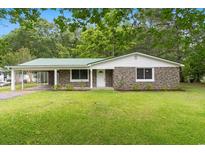 Charming stone and siding home featuring a green metal roof, well-kept lawn, and an attached carport at 96 Middleton Rd., Andrews, SC 29510