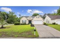 Charming single-story home with a well-manicured lawn, black mulch, and an attached garage at 9831 Winchester Ct., Murrells Inlet, SC 29576