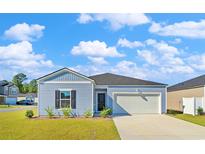 Charming single-story home with blue siding, an attached garage, and a well-manicured front lawn at 1004 Sentinel Ct., Little River, SC 29566
