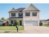 Charming two-story home featuring a well-maintained lawn and a two-car attached garage at 1031 Snowberry Dr., Longs, SC 29568
