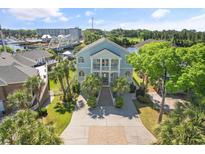 Stunning two-story home with a grand entrance, lush landscaping, and a beautiful view of the waterway and bridge at 107 Waterway Crossing Ct., Little River, SC 29566
