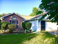 Inviting single-story home featuring a brick facade, siding, manicured landscaping, and an attached garage at 131 Goodale Dr., Longs, SC 29568