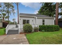 Charming single-story home with gray siding, well-manicured lawn, and inviting front porch at 1590 Landing Rd., Myrtle Beach, SC 29577
